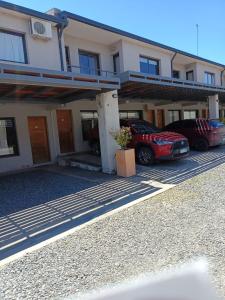 科尔多瓦Complejo NOVIEMBRE的两辆汽车停在一栋建筑前的停车场