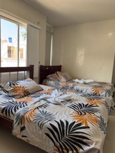 two twin beds in a bedroom with a window at Hostal la 200 in Floridablanca +7 photos