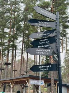 un letrero de la calle con flechas apuntando en diferentes direcciones en Lägenhet nära Isaberg, en Nissafors