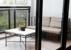 een balkon met een bank en een tafel bij Hotel Palermitano by DOT Boutique in Buenos Aires