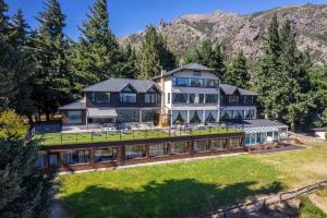 Una vista aérea de una casa grande con montañas al fondo. en Estancia Del Carmen Mountain Resort, en San Carlos de Bariloche