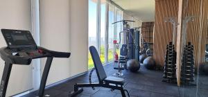 a gym with exercise equipment and a laptop on a treadmill at Dream Apartment-Rooftop, Pool, Mountain & Sea View in Capão da Canoa