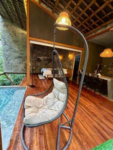 una sedia a dondolo in una stanza con piscina di Cabaña El Bosque Encanto Natural y Jacuzzi Privado a Sopetrán