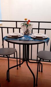a table with plates and glasses and a vase on it at Flor de Loto in Candeleda
