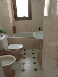 a bathroom with a toilet and a tub and a sink at Flor de Loto in Candeleda