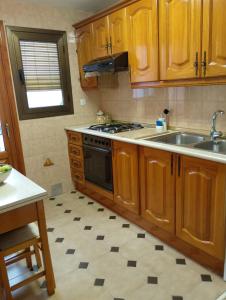 a kitchen with wooden cabinets and a stove and a sink at Flor de Loto in Candeleda