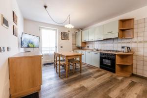 a kitchen with white cabinets and a wooden table at Residenza Andreotti in Ossana