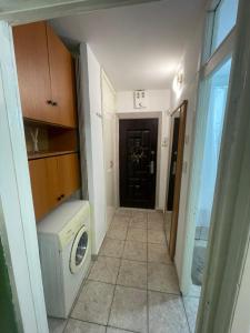 a laundry room with a washing machine and a door at Studio Modest in Craiova