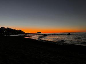 een zonsondergang op een strand met rotsen in het water bij Domo Algarrobo 1 in San Antonio
