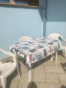 丽都玛里尼Casa Azzurra的一张桌子上放着一份报纸，旁边有两把椅子。