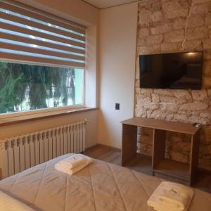 a bedroom with a bed and a tv and a window at Немирівель in Nemirov