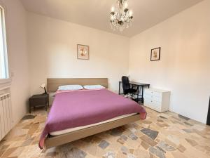 a bedroom with a bed and a desk and a chandelier at Family 3-Bedroom Apartment near MXP & Lake Maggiore - Parking in Sesto Calende