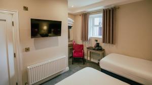 a hotel room with a bed and a red chair at JUST B Townhouse in Dingle