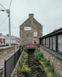 a brick building with a bridge in front of it at JUST B Townhouse in Dingle