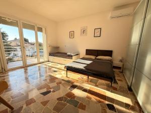 a bedroom with a bed and a large window at Family 3-Bedroom Apartment near MXP & Lake Maggiore - Parking in Sesto Calende