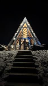 Una iglesia con escaleras en la nieve por la noche. en Villa Šašava, en Bosanska Gradiška