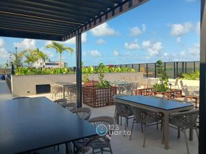 um pátio com mesas e cadeiras num telhado em Hit Cabo Branco by 123Quarto em Tambaú