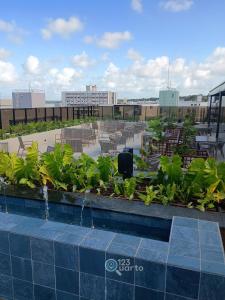een dakterras met tafels en stoelen bij Hit Cabo Branco by 123Quarto in Tambaú