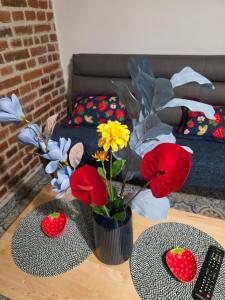 a table with a vase with flowers on it at Apartament klimatyczny in Piece