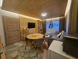 una sala de estar con una mesa y un sofá en Apartmán Queen, en Stará Lesná