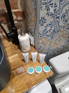 a table with three cups and a toilet in a bathroom at Apartament klimatyczny in Piece