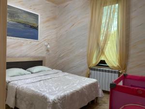 una camera da letto con un letto e una finestra di David guest house LOFT Коттеджи на берегу реки a Dilijan