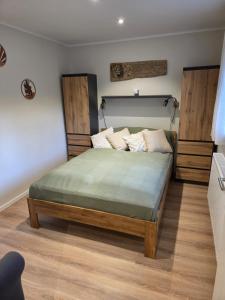 Cozy Luhe Cottage في بيسبينغين: غرفة نوم بها سرير كبير ذو عناصر خشبية