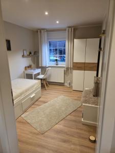 Cozy Luhe Cottage في بيسبينغين: غرفة نوم بها سرير ومكتب ونافذة