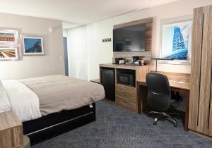 a hotel room with a bed and a desk with a television at Quality Inn Ponca City in Ponca City