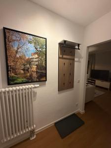 ein Wohnzimmer mit einem Gemälde an der Wand und einem Heizkörper in der Unterkunft Krämernest in Erfurt