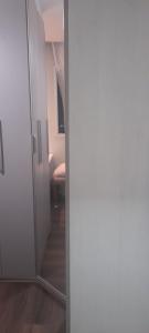 una porta aperta su un corridoio con specchio di Dois Quartos Completo a Vila Velha