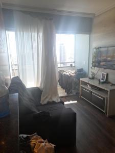 un soggiorno con divano, tavolo e finestra di Dois Quartos Completo a Vila Velha