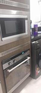 un forno a microonde e una lavastoviglie in una cucina di Dois Quartos Completo a Vila Velha Altre 4 foto