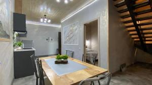 una sala da pranzo con tavolo in legno e una cucina di David guest house LOFT Коттеджи на берегу реки a Dilijan