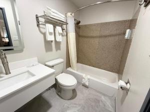 a white bathroom with a toilet and a sink at Quality Inn Ponca City in Ponca City +18 photos
