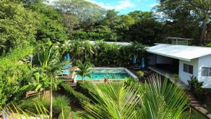 タマリンドにあるTee-K Lodge Tamarindoのスイミングプールと木々のある家の空中風景 +14枚の写真