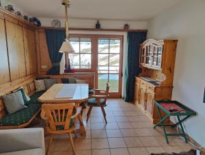 a living room with a table and chairs and a kitchen at Sonnenbichl in Berwang