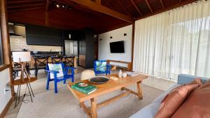 a living room with a couch and a table at Casa 09 Monte Boa Vista - Refúgio com Piscina Privativa, Sauna e Vista das Montanhas in Teresópolis