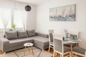 a living room with a couch and a table and chairs at Apartman Odmor012 in Požarevac