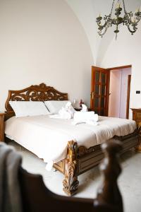 a bedroom with a large bed with white sheets at A Casa di Nonna Nunzia - Centro di Gravina - 20min da Matera in Gravina in Puglia