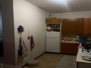 a kitchen with a white refrigerator and a counter at SnowPeak Residence in Dresano