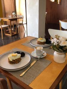 a table with two plates of food and a cup of coffee at Residencial P&P in Mindelo