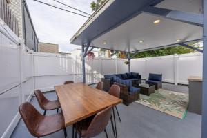 a patio with a wooden table and chairs at 7BR 5BTH House Steps to Bars Dining NYC Access with GameRm Backyard with BBQ and Parking in Jersey City