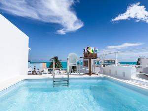 a swimming pool on the roof of a house with the ocean at Casa Cuatro Estaciones in Puerto Morelos