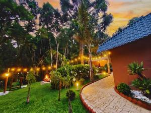 een huis met een tuin 's nachts met verlichting bij Pousada Villa Bergamin, Monte Verde in Monte Verde