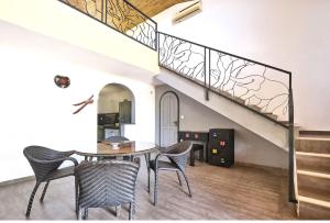 NianingVILLA PAULINE Nianing2的一间有桌椅和楼梯的餐厅