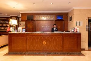 a man sitting at a bar in a hotel lobby at Taksim Pera Rose Hotel & Spa - Istiklal Street in Istanbul