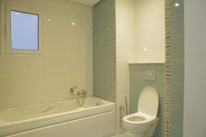 a bathroom with a toilet and a tub and a sink at Duplex el 3ebdelleyya en face tennis club la marsa in Tunis +32 photos