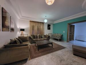 a living room with two couches and a table at Duplex el 3ebdelleyya en face tennis club la marsa in Tunis