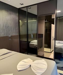 ein Schlafzimmer mit einem Bett mit einer weißen Schleife darauf in der Unterkunft High Luxury Geta on the 18th Floor Vertigo Studios in Campo Grande